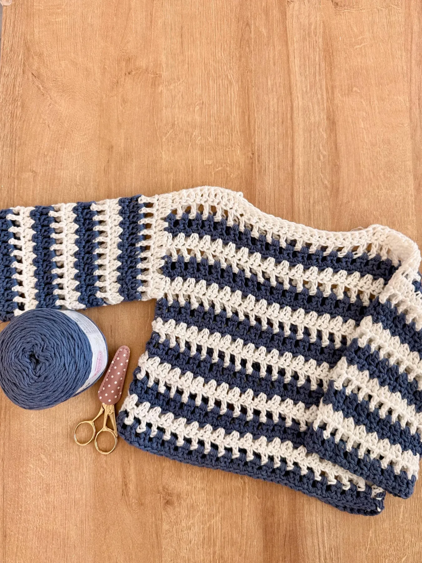 Navy and white striped Saltwater Drift kids' top beside yarn